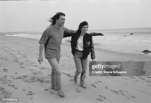 View of married couple, American actress Valerie Bertinelli and Dutch-born American Rock musician Eddie Van Halen as they walk on the beach, Los...