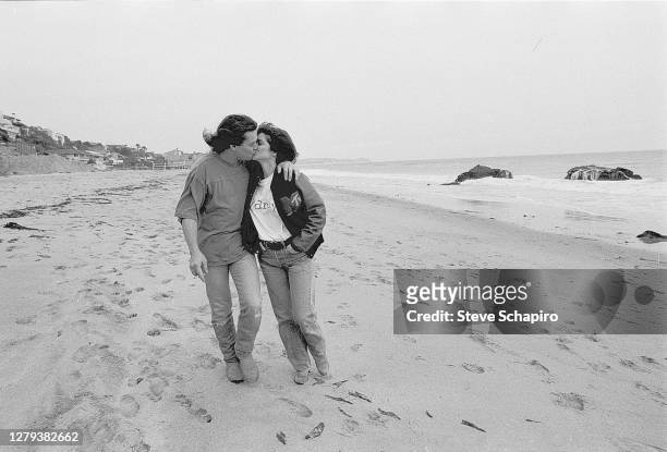View of married couple, American actress Valerie Bertinelli and Dutch-born American Rock musician Eddie Van Halen as they kiss on the beach, Los...