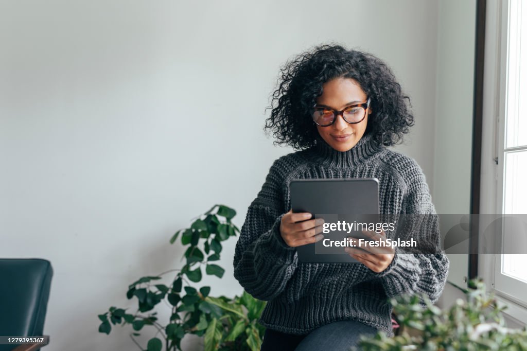 Working from Home: a Young Woman USing a Digital Tablet to Read/Watch Something