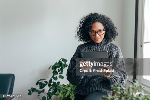 Working from Home: a Young Woman USing a Digital Tablet to Read/Watch Something Working from Home: a Young Woman USing a Digital Tablet to Read/Watch Something