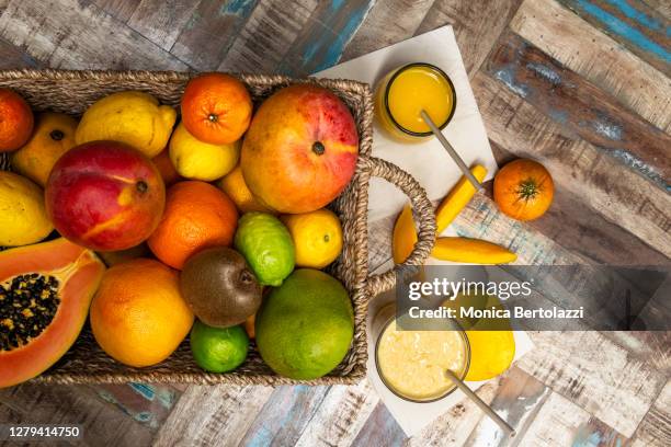 basket containing citrus fruits and tropical fruits - tropical fruit stock pictures, royalty-free photos & images