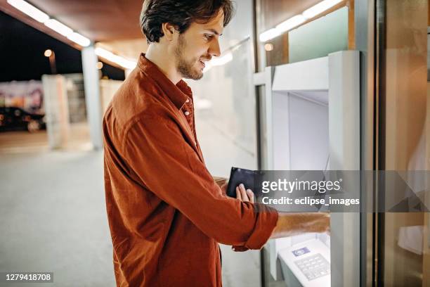 men using atm machine to withdraw money - man atm smile stock pictures, royalty-free photos & images