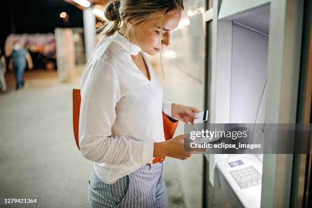 mujeres que usan cajeros automáticos - bank holiday fotografías e imágenes de stock