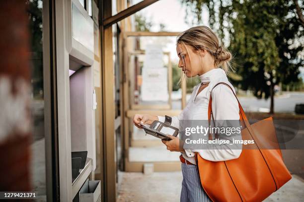 vrouwen die atm machine gebruiken om geld op te nemen - wallet stockfoto's en -beelden