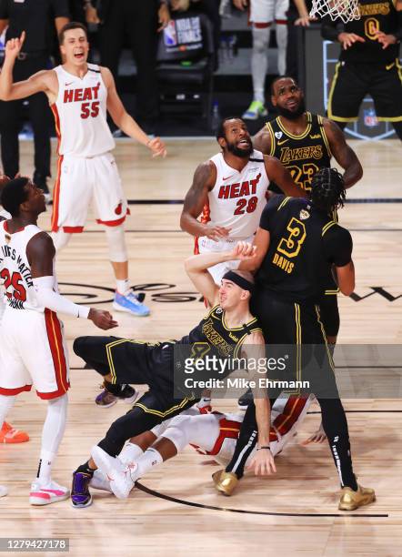 Alex Caruso of the Los Angeles Lakers attempts a shot as Jimmy Butler of the Miami Heat and Andre Iguodala of the Miami Heat defend during the third...