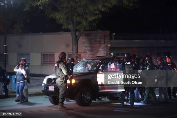 Police take people into custody who were out after curfew follow a brief skirmish with demonstrators near the Wauwatosa City Hal on October 09, 2020...