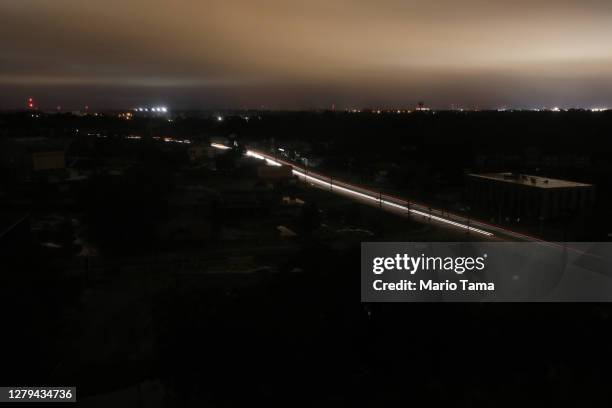 Cars move through a section of the city suffering a power outage during Hurricane Delta on October 9, 2020 in Lafayette, Louisiana. Hurricane Delta...