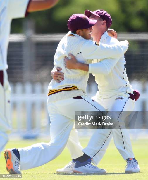 Usman Khawaja of the Queensland Bulls hugs Marnus Labuschagne of the Queensland Bulls after catching the wicket of Nathan Ellis of the Tasmanian...