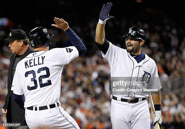 Don Kelly and Alex Avila of the Detroit Tigers celebrate after Kelly scored on a double by Jhonny Peralta in the sixth inning of Game Three of the...