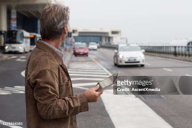man wait for taxi at airport arrivals - milan airport stock pictures, royalty-free photos & images
