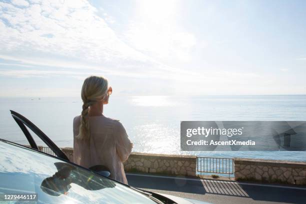 mature woman relaxes beside car door - early retirement stock pictures, royalty-free photos & images