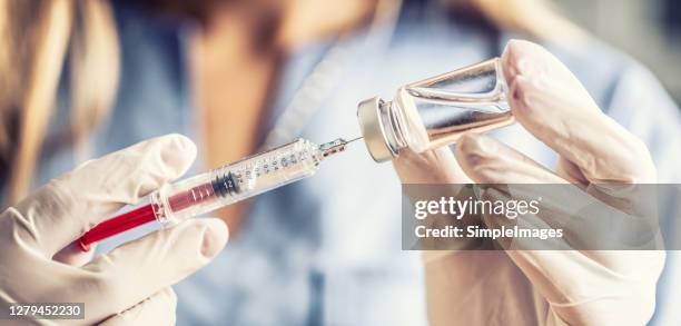 syringe needle and vaccine in the hands of a nurse. preparation of coronavirus vaccine - covid-19 - covid 19 vaccine vial stock pictures, royalty-free photos & images