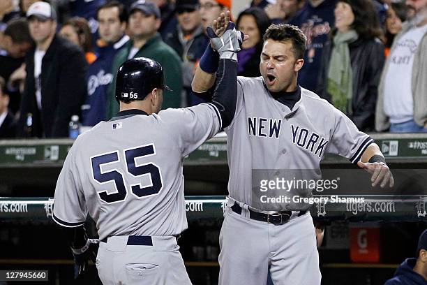 Russell Martin and Nick Swisher of the New York Yankees celebrate after Martin scored on a double by Brett Gardner in the seventh inning of Game...