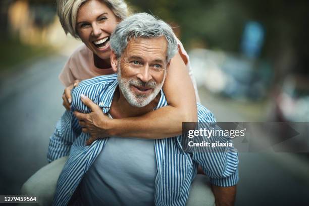 middle aged couple having fun outdoors. - mid adult couple stock pictures, royalty-free photos & images