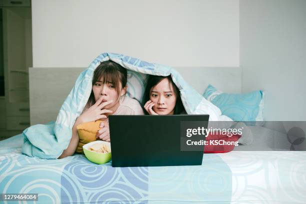 two beautiful asian women watching movie at home. - woman watching horror movie stock pictures, royalty-free photos & images