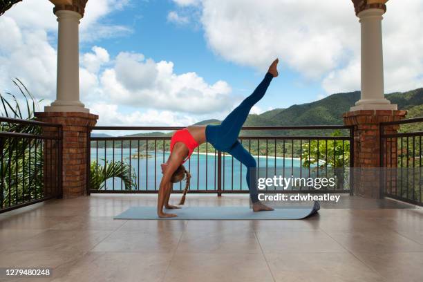 attractive woman exercising  on a private deck at a luxury villa - private terrace balcony stock pictures, royalty-free photos & images