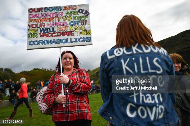 Protesters with placards gather outside the Scottish Parliament entrance to demonstrate against new coronavirus restrictions, face covering rules and...