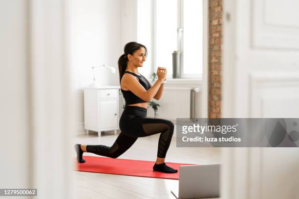 donna che fa affondo mentre guarda tutorial di esercizi - affondo foto e immagini stock