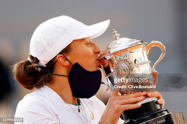 Iga Swiatek of Poland kisses the Suzanne-Lenglen cup following victory in her Women's Singles Final against Sofia Kenin of The United States of...