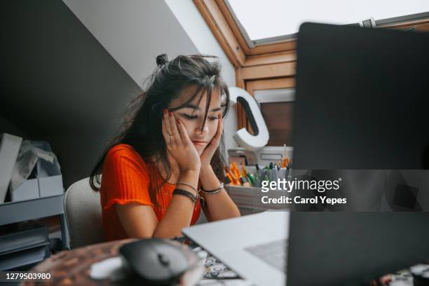 female teenager feeling stressed studing at home.e learning.home schooling - studie exam stockfoto's en -beelden