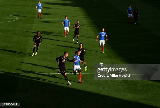 Richard Keogh of Milton Keynes Dons and Marcus Harness of Portsmouth chase the ball during the Sky Bet League One match between Portsmouth and Milton...