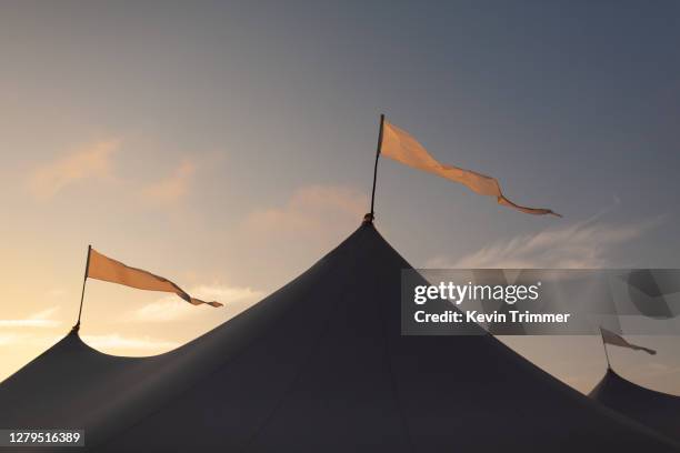 flags on-top of large event tent during sunset - entoldado fotografías e imágenes de stock