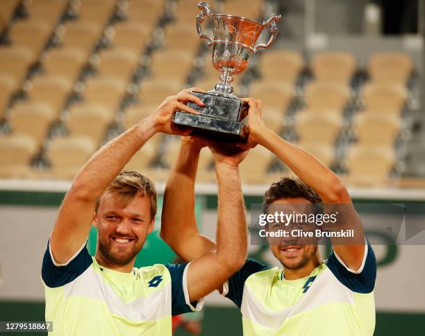 Kevin Krawietz and Andreas Mies of Germany lift the winners trophy following victory in their Men's Doubles Final on Court Philippe-Chatrier against...