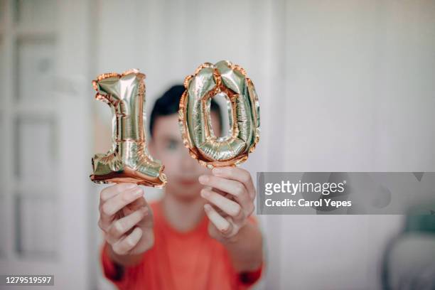 selective focus boy holding golden 10 air balloon - silver balloon imagens e fotografias de stock
