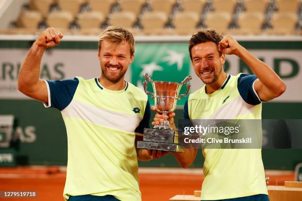 Kevin Krawietz and Andreas Mies of Germany lift the winners trophy following victory in their Men's Doubles Final on Court Philippe-Chatrier against...