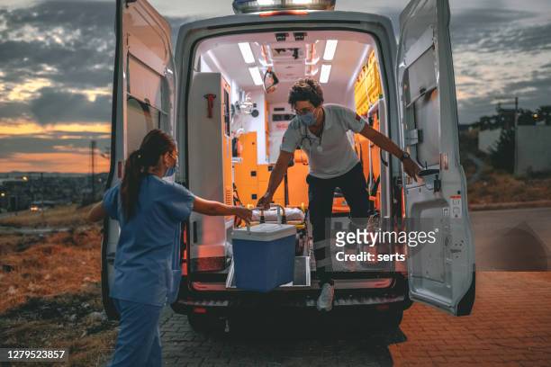 medizinisches team in eile tragen organtransplantationen box mit krankenwagen während der pandemie - inneres organ stock-fotos und bilder