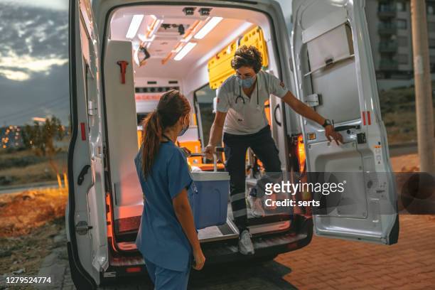 medical team in a hurry carrying organ transplants box by ambulance during pandemic - refrigeration transport stock pictures, royalty-free photos & images