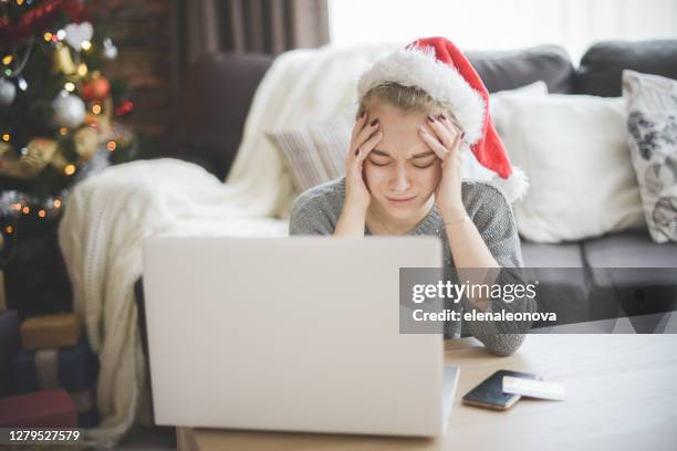 young woman in christmas interior with laptop  ( negative emotions) - retail economy ahead of christmas holiday season imagens e fotografias de stock