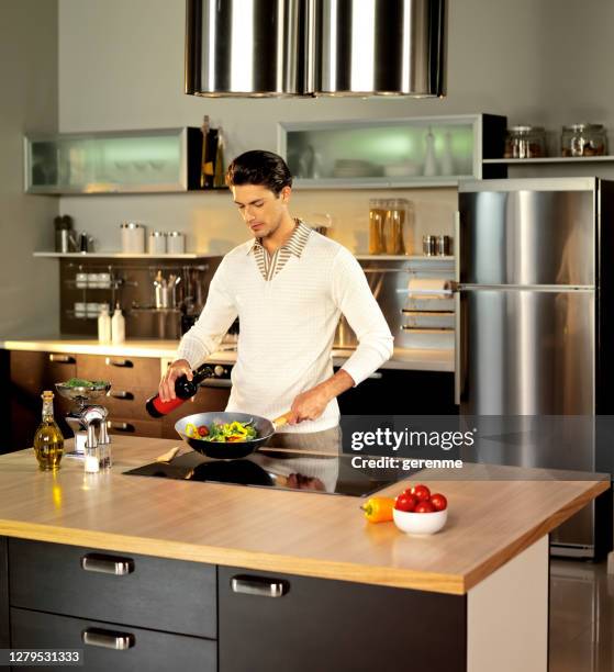 koken in chique keuken - keramische plaat stockfoto's en -beelden
