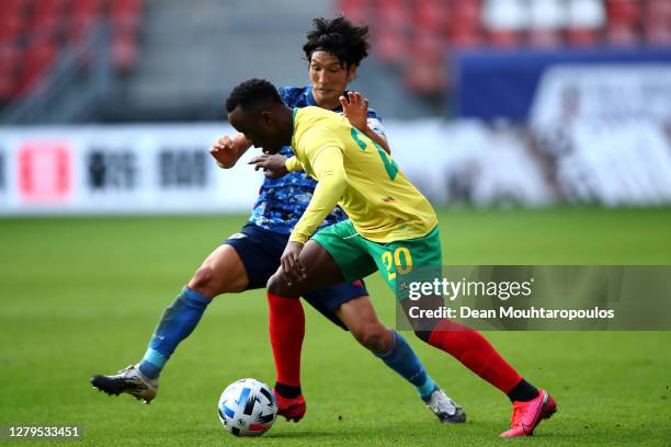 Fabrice Olinga of Cameroon battles for the ball with Genki Haraguchi of Japan during the international friendly match between Japan and Cameroon at...