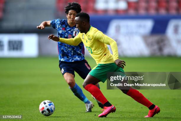 Fabrice Olinga of Cameroon battles for the ball with Genki Haraguchi of Japan during the international friendly match between Japan and Cameroon at...