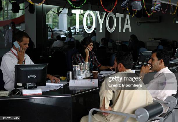 Sales clerks assist customers at the Toyota Central Motors dealership in Karachi, Pakistan, on Monday, Oct. 3, 2011. Indus Motor Co., the Pakistan...