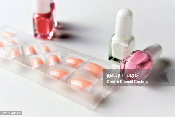 false nails and nail polish on white background - künstlicher fingernagel stock-fotos und bilder