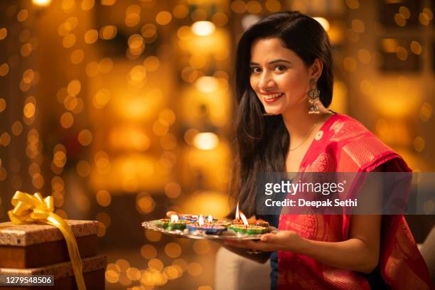 mujer joven diwali celebrar en casa - foto de stock - diya oil lamp fotografías e imágenes de stock