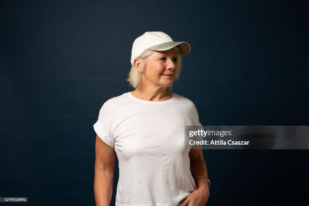 Mature sporty woman looking at distance wearing baseball cap