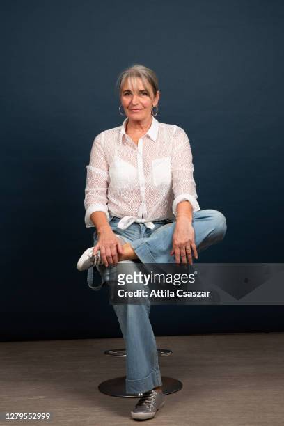 sitting portrait of senior woman wearing jeans - grey hair cool woman stock-fotos und bilder