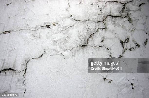 cracked white paint on a damp and mouldy wall - wet cement stock pictures, royalty-free photos & images