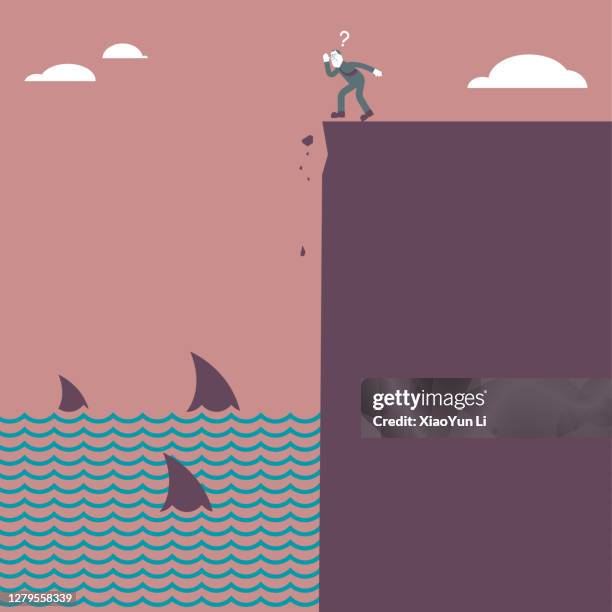 illustrazioni stock, clip art, cartoni animati e icone di tendenza di un uomo si trova sul bordo di una scogliera in fondo al mare, e ci sono scuole di squali nel mare. - pinna animale