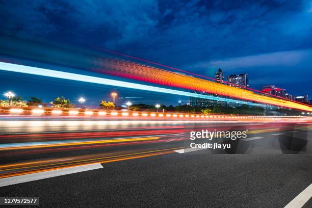 in the evening, the track of car headlights on the highway. guangzhou, china. - brake lights foto e immagini stock