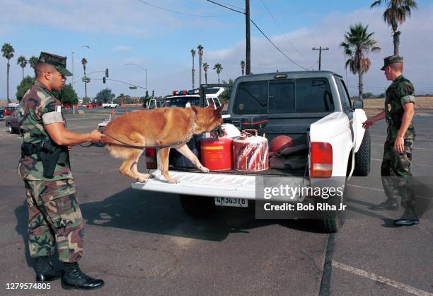 Military Police and K9 officers check identification and search vehicles entering Camp Pendleton military base, September 12, 2001 in Oceanside,...