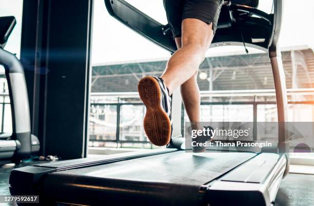 unrecognizable male athlete running on treadmill in health club. - male feet imagens e fotografias de stock