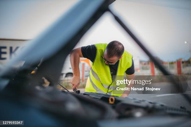 man repairing car on road - roadside stock pictures, royalty-free photos & images