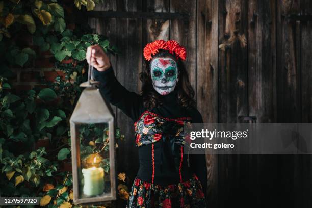 teenager-mädchen in gruseligen halloween-kostüme halten laterne in der nacht - horror girls stock-fotos und bilder