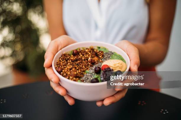 vrouw die smoothiekom eet - smoothie stockfoto's en -beelden