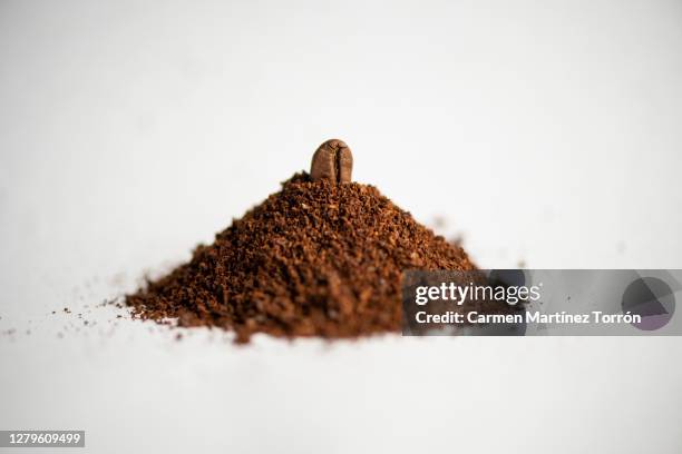 mountain of ground coffee, with a coffee beans in the peak. - coffee powder bildbanksfoton och bilder
