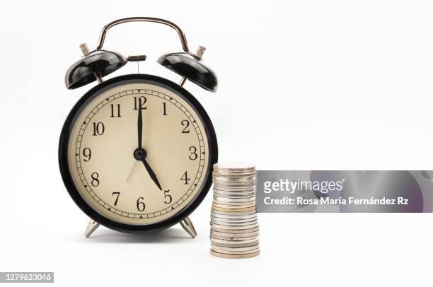 head of coins and alarm clock on white background. concep "time y money" - uhrzeiger stock-fotos und bilder